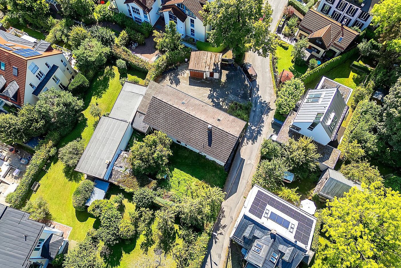 Luftaufnahme eines Grundstücks in der etablierten Münchner Wohnlage Solln mit umliegenden Einfamilienhäusern und großzügigen Gärten